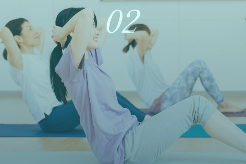 ジムで女性たちがグループで腹筋トレーニングを行う様子