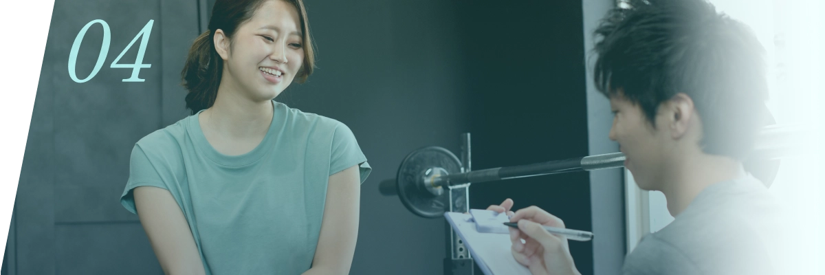 ジムで女性がトレーナーとカウンセリングを受ける様子